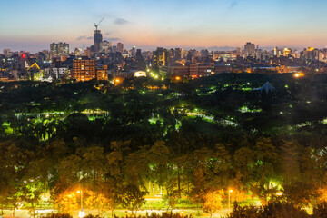 Sunset high angle view of the Daan Forest Park and cityscape
