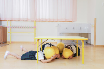 ヘルメットを被り避難する子供