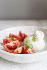 Italian burrata cheese with tomatoes and olive oil. Light summer dinner or snack. Healthy eating. Vegetarian food. Selective focus