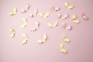 small light pink bats on a pink background with a place for text, the concept of a creative happy Halloween
