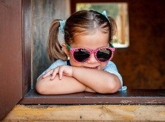 Young girl wearing sunglasses in playground