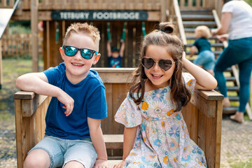 Happy boy and girl sitting in park