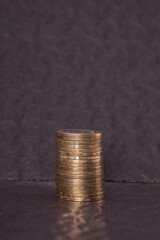 Close-up of coins stack on black background. 
