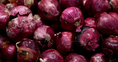 Onions at grocery store piled together on display