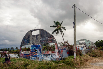 Abandoned American army quonset hut, concrete structure remaining and graffiti - obrazy, fototapety, plakaty