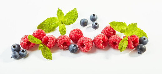 Raspberries and blueberries on white background