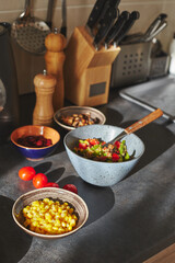 Sunliht modern kitchen with plate of quinoa filled with vegetables and ingredients on the countertop.
