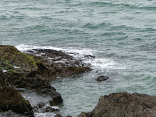 Fototapeta na wymiar Wild rock, rock formation beside of water. Ocean waves & Coastal Cliffs