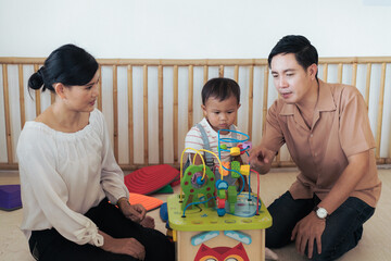 Obraz premium Dad Mother and daughter playing with toy at home. Happy Asian family girl kid playing with mom