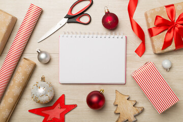 Gift boxes, paper's rools and decorations on wooden background, top view