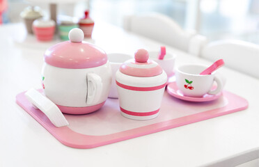 A set of pink white pastel color wood  toy tea cups including 2 coffee cups with teaspoons, a...