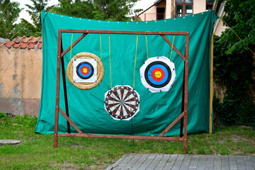 A close up on three targets used for arrow shooting practice hanging from ropes or strings and...