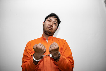 Prisoner in orange robe concept,Portrait of asian handsome man in Prison uniforms,Bandit has a lot...