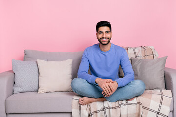 Photo of sweet shiny arab guy dressed blue pullover sitting couch empty space isolated pink color background