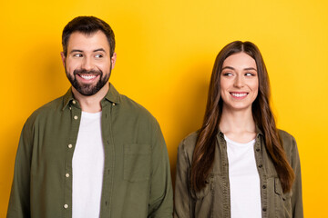 Portrait of positive friendly people toothy smile look each other isolated on yellow color background