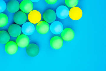 Abstract colored balls background. Multi-colored taw toy scattered on bright paper. Base for design nice backdrop, wallpaper, poster. Noisy surface texture