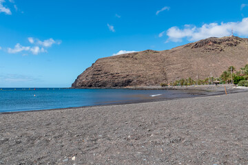 Obraz premium Panoramic view from the beach Playa de San Sebastian on Cruz de Machal in San Sebastian de La Gomera, La Gomera, Canary Islands, Spain, Europe. Dark lava sand beach. Mountains in the back