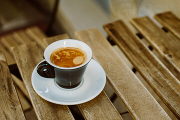 Cup of black coffee on a table in a street cafe. Selective focus.