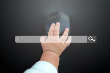 Search bar of internet browser and baby hand working on computer at desk.