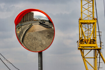 Mirror on the road leading to the construction site. Road safety. Visibility behind a dangerous...