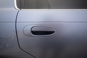 Handle of a silver car door	