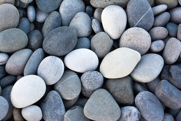 Abstract background with round pebble stones. Stones beach smooth. Top view. Summer day.