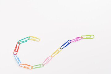 Top view colorful paper clips isolated on white background. High key photography.