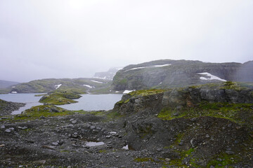 die wunderschöne karge Landschaft im Aurlandsfjellet mit See, Schnee und Nebel  im August in Norwegen