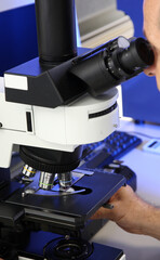 Man medical Doctor or research scientist looking through a microscope in a laboratory.science experiments, laboratory glassware containing chemical liquid for researching biology chemistry samples