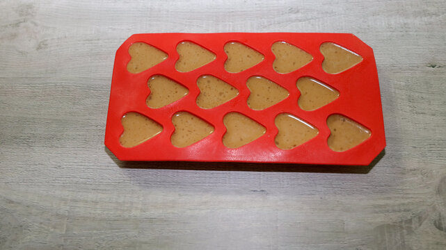 Almond butter, coconut oil and cinnamon mixture in heart shape silicone mold for making fat bombs.