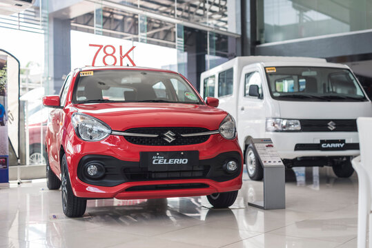 Manila, Philippines - Sept 2022: A Suzuki Celerio Subcompact Car And Carry Utility Van On Display At A Dealership Showroom.