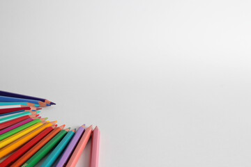 Set of colored pencils on white background. Pencils of various colors aligned to the left in circular shape.