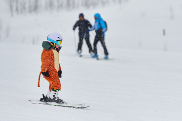 Child in a tiger costume is skiing