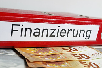 Closeup of isolated red file folder with german word Finanzierung (engl. Translation: financing),...