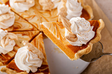 Pumpkin cheesecake swirl pie topped with whipped cream - obrazy, fototapety, plakaty