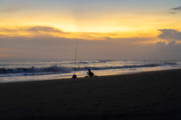 A fisherman is fishing with a fishing rod on the ocean, Bali, Indonesia.