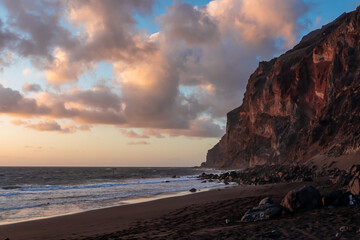 Scenic view during sunset on the volcanic sand beach Playa del Ingles in Valle Gran Rey, La Gomera, Canary Islands, Spain, Europe. Massive cliffs of the La Mercia range. Close up on Rock formation