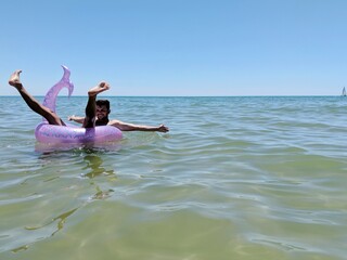 man posing on the sea in Portugal on his inflatable rubber part