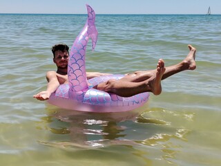 man posing on the sea in Portugal on his inflatable rubber part
