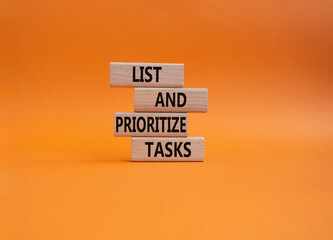 List and prioritize tasks symbol. Concept words List and prioritize tasks on wooden blocks. Beautiful orange background. Business and List and prioritize tasks concept. Copy space.
