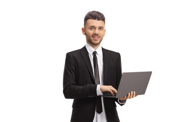 Young businessman standing and working on a laptop