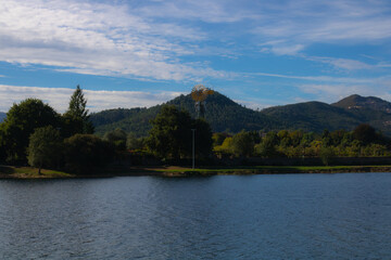 lake and mountains with green trees and a mill