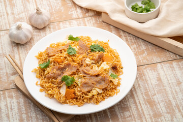 Stir fried instant noodles with BBQ pork sauce in white plate