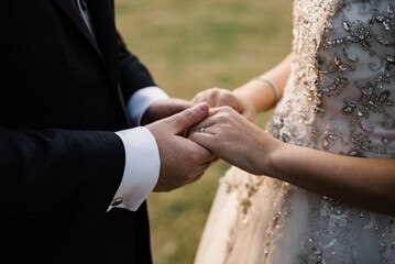 Bride and groom holding hands on the wedding.