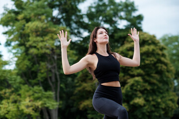 Portrait of young caucasian woman doing yoga in a forest.