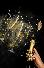 Glass of champagne and bottle on dark background.