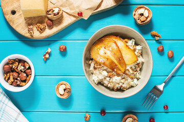 Pear and gorgonzola oatmeal with walnuts on blue wooden table.