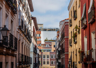 Exterior view of beautiful historical buildings in Central Madrid, Spain, Europe. Colorful street scene in the Letras neighborhood of the Spanish capital. Facade of traditional heritage buildings.