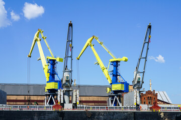 Fototapeta na wymiar Port cranes painted in the colors of the Ukrainian flag, yellow and blue
