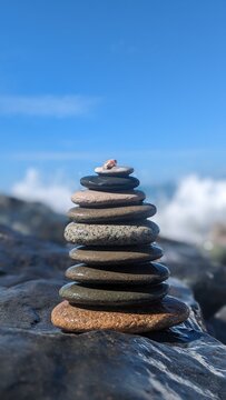 Pyramid of pebbles on the beach Batumi Adjara Georgia. 
Selective focus Abstract bokeh with Sea on the background. Zen stones on the beach. Meditation, spa, harmony, calmness, peace concept.